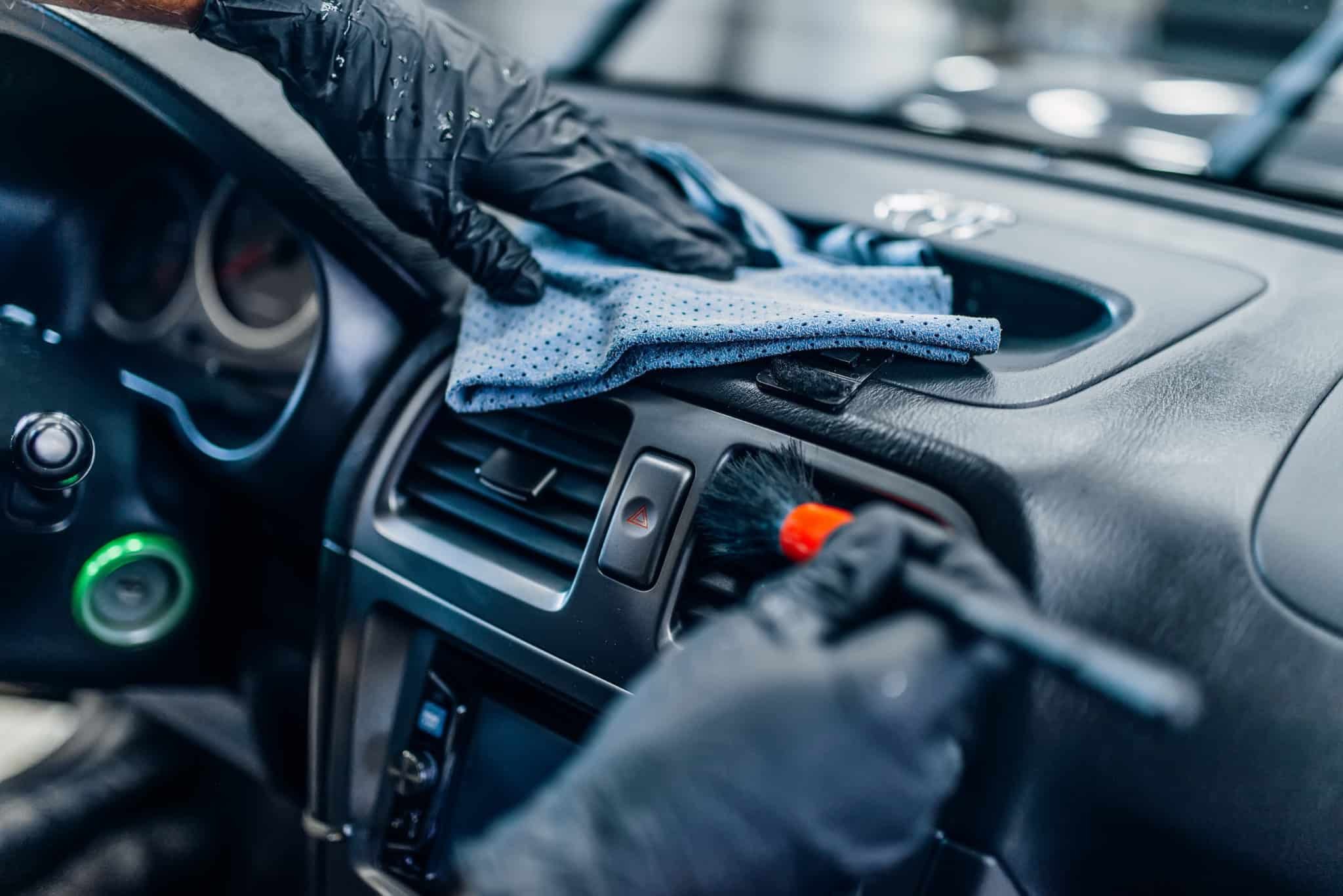 Technician hand-detailing a car's dashboard and interior trim at Makanga Auto Centre
